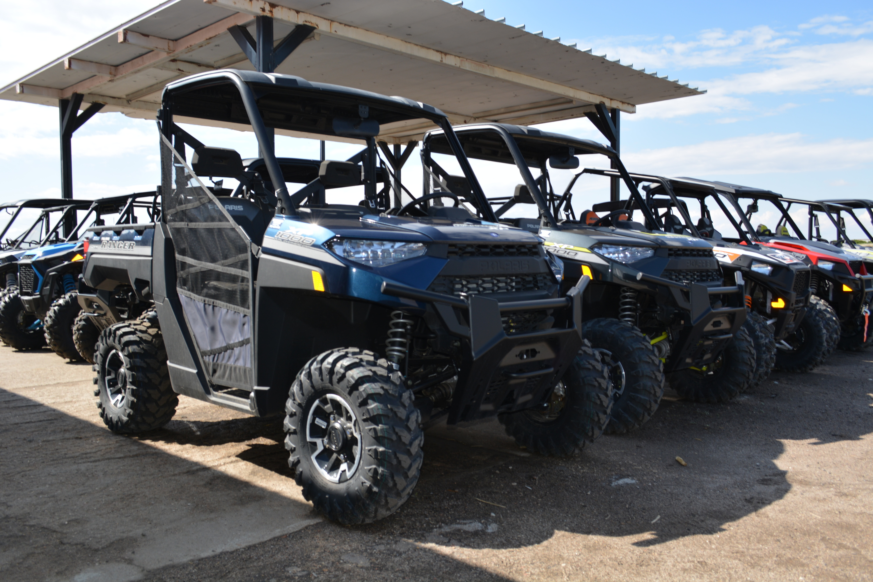 A row of Polaris® side by side in a parking lot.